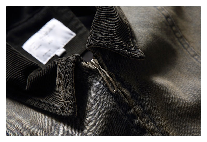 Close-up of the jacket's black ribbed collar and metal zipper against gray-brown fabric.