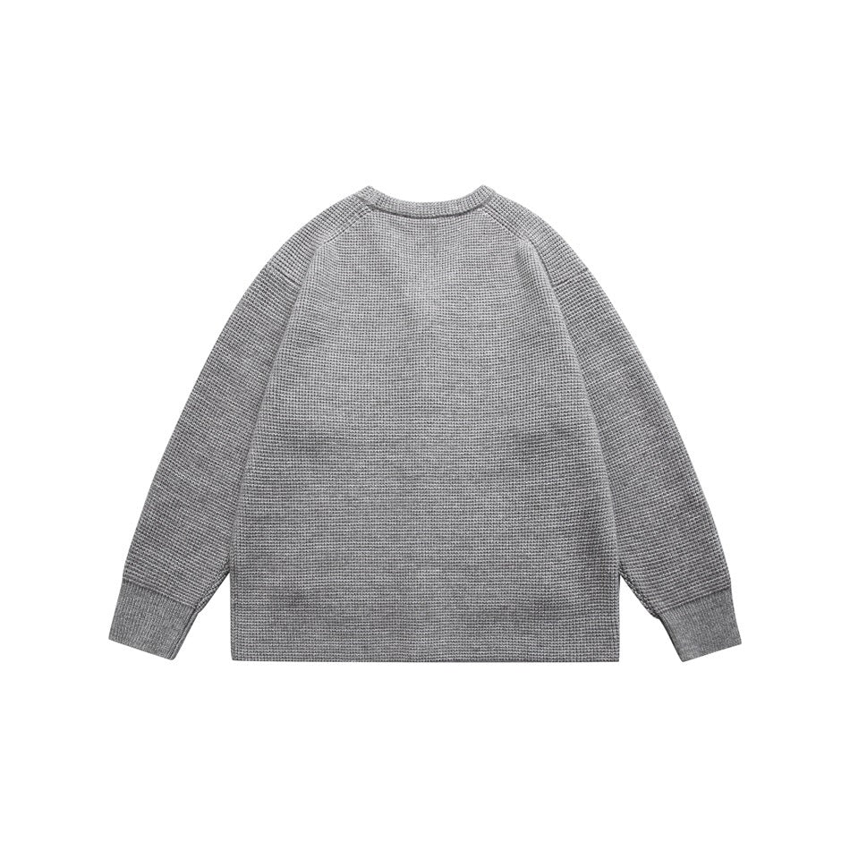 Back view of a light gray knit cardigan with raglan sleeves and ribbed cuffs.