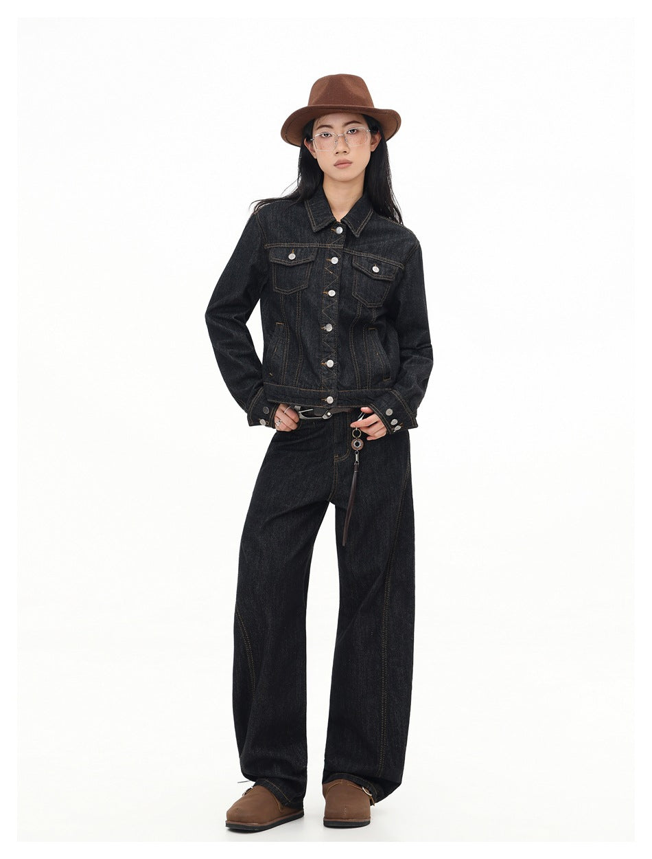 Full-length model wearing a buttoned dark indigo denim jacket with contrast stitching and matching wide-leg jeans.