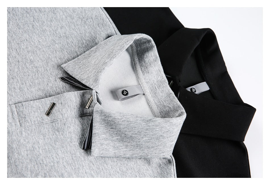 Close-up of gray and black collared shirts, showing the collars, chest pockets and small metal accents.