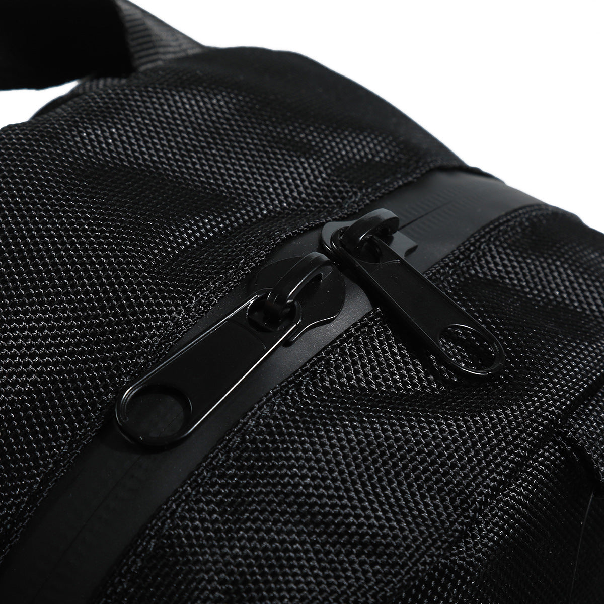 Close-up of two black zipper pulls on a textured black bag.