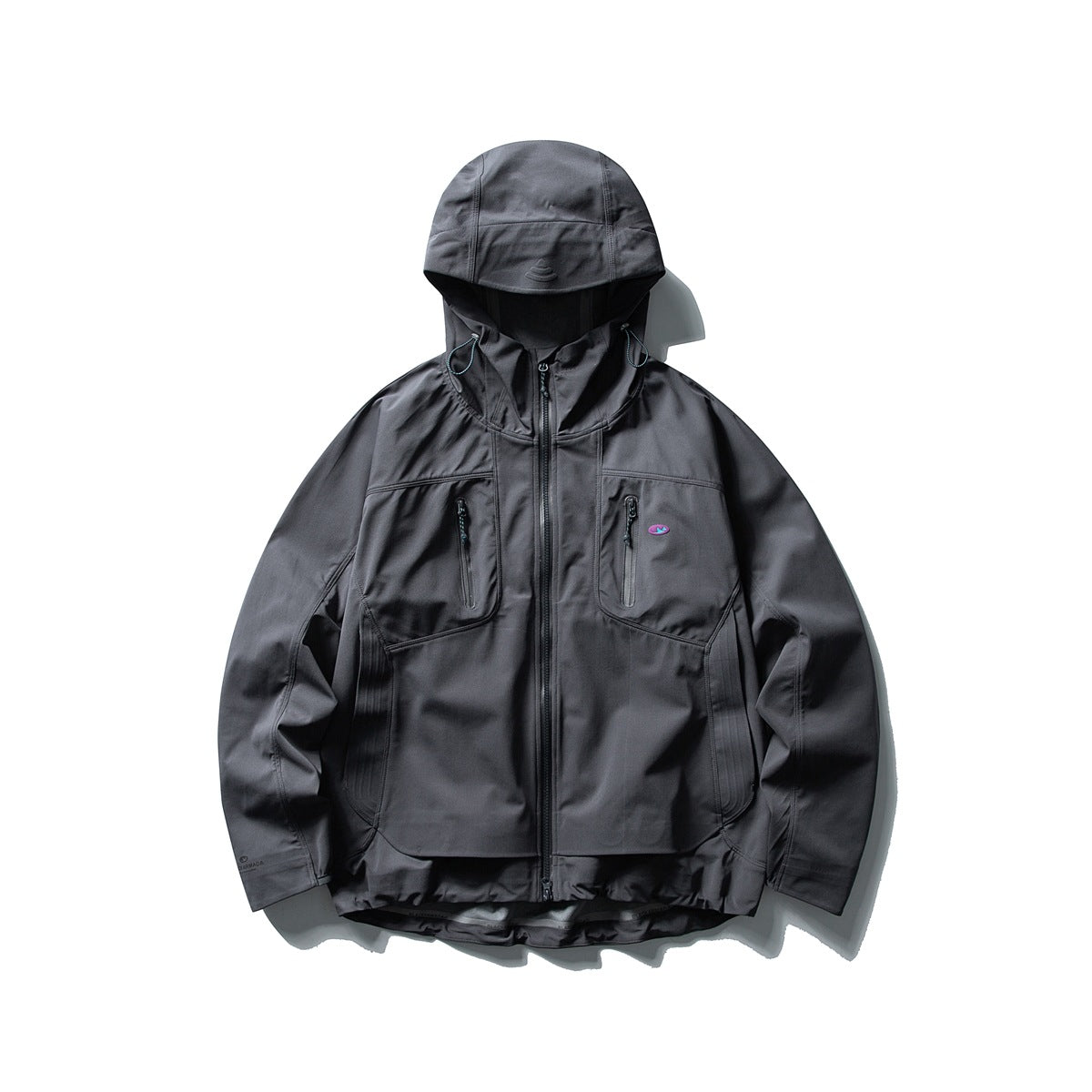 Dark gray hooded zip jacket with two zipped chest pockets, side panels and a curved layered hem, flat lay