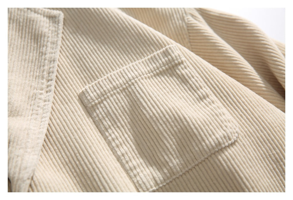 Close-up of a rectangular patch pocket and ribbed corduroy texture on a cream jacket.