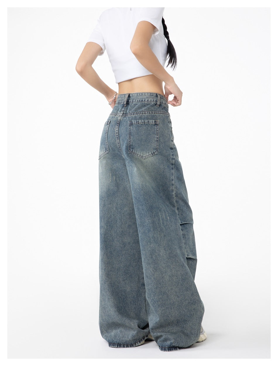 Back view of a model wearing faded blue, high-waisted jeans with very wide legs and two rear pockets.