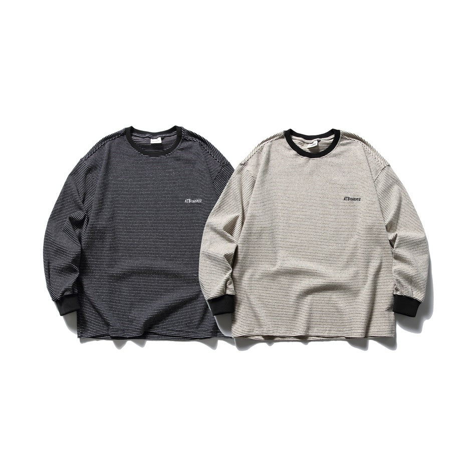 Two striped long-sleeve shirts displayed side by side in black and light beige, both with black collars and cuffs.