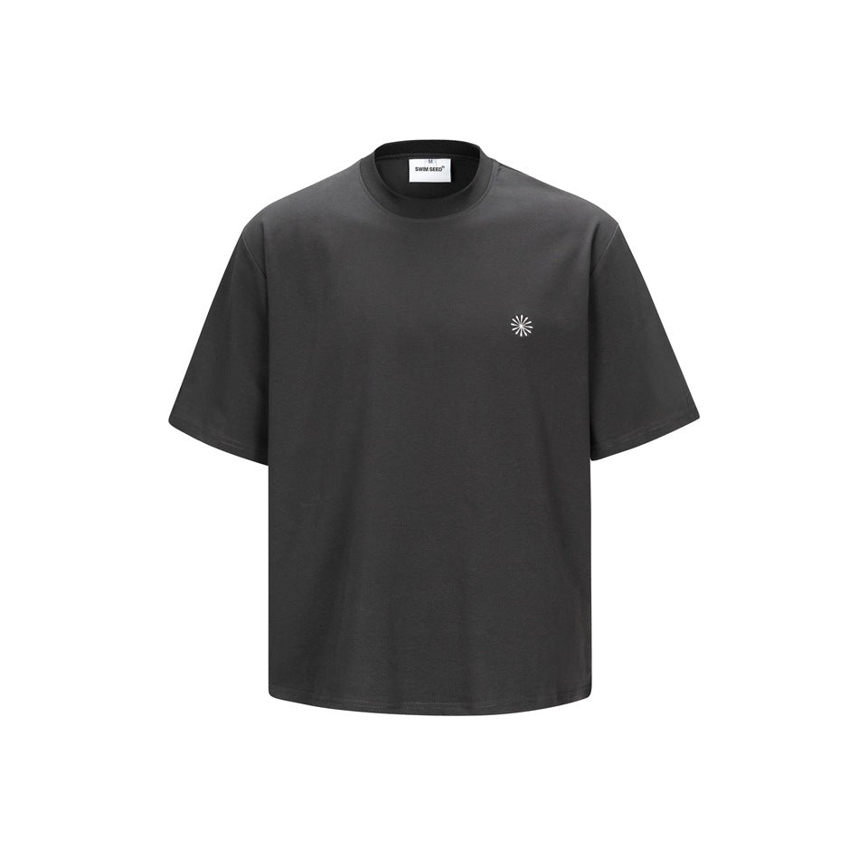 Dark gray short-sleeve crew-neck T-shirt, front view, with a small light sunburst emblem on the left chest