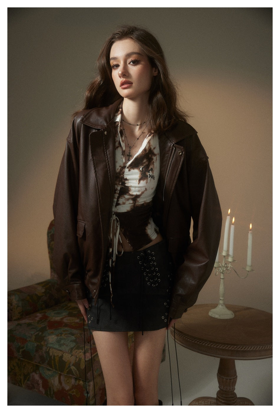 Front view of a model wearing a dark brown leather-look jacket with a wide collar and zip front.