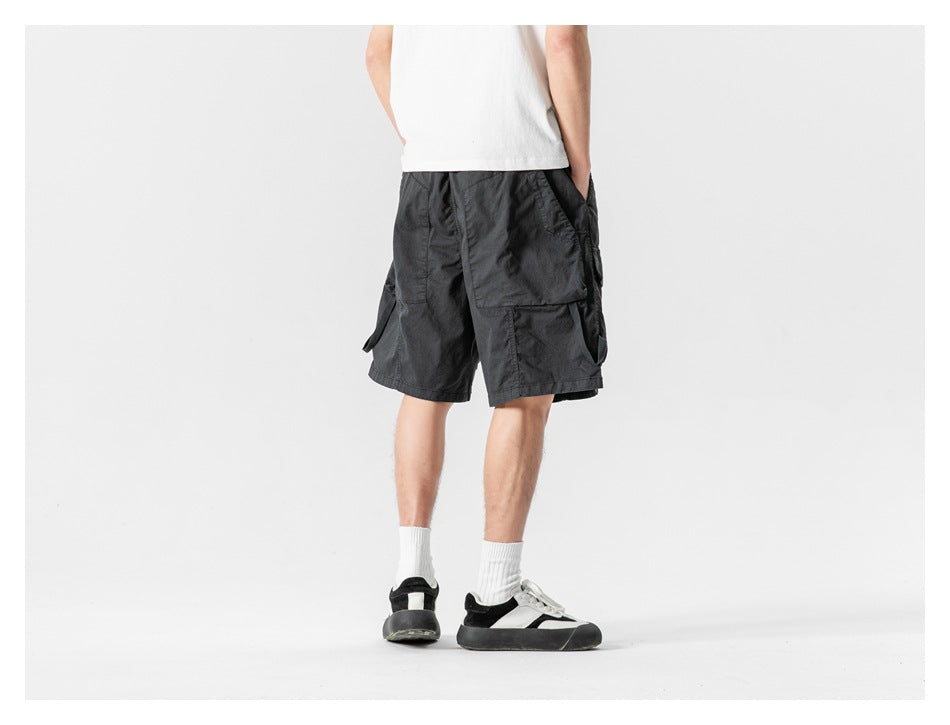 Back view of a model wearing black cargo shorts with large rear flap pockets.