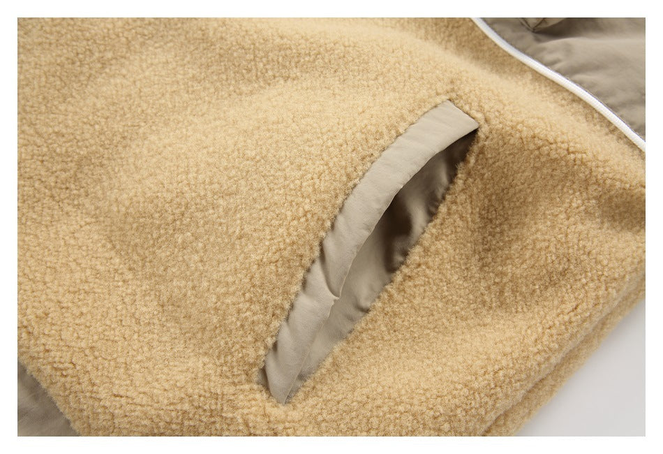 Close-up of a slanted pocket opening edged with smooth tan fabric on a tan fleece jacket.