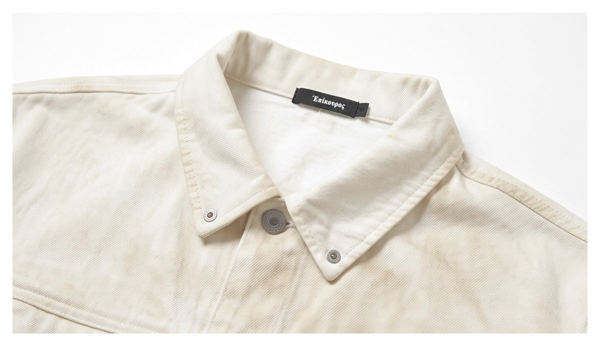Close-up of an ivory jacket collar, metal snaps, and black Greek-text neck label.