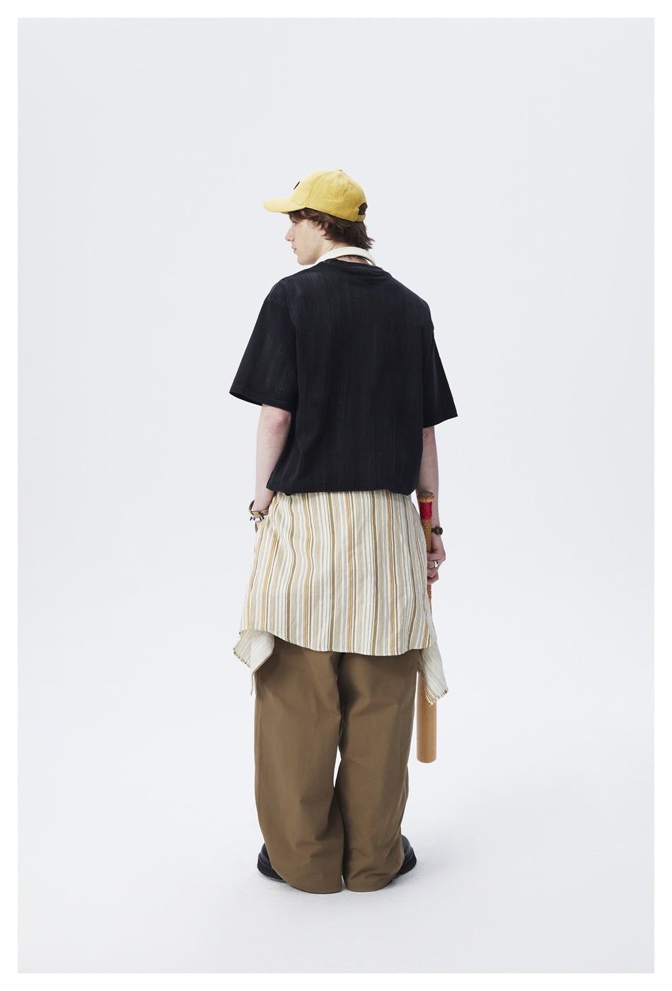 Model wearing a black oversized T-shirt, shown from the back.