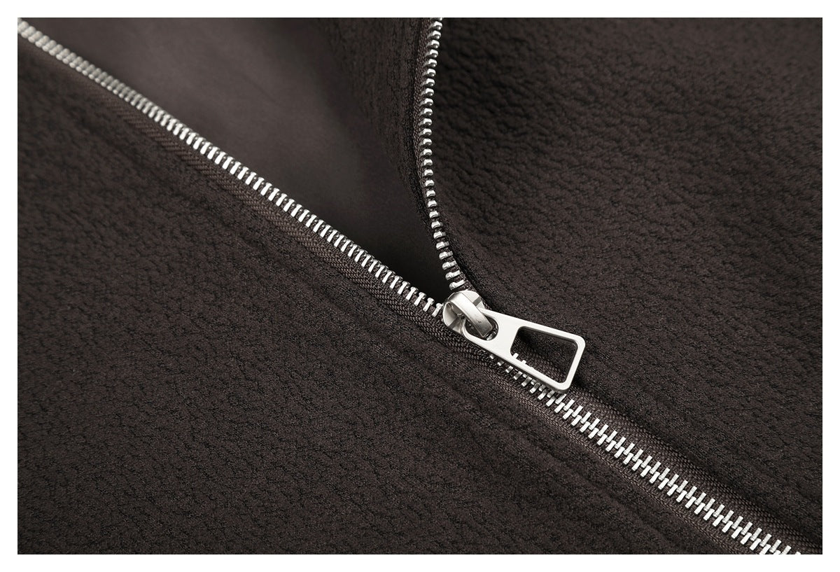 Close-up of a silver zipper and pull on dark brown textured fabric.