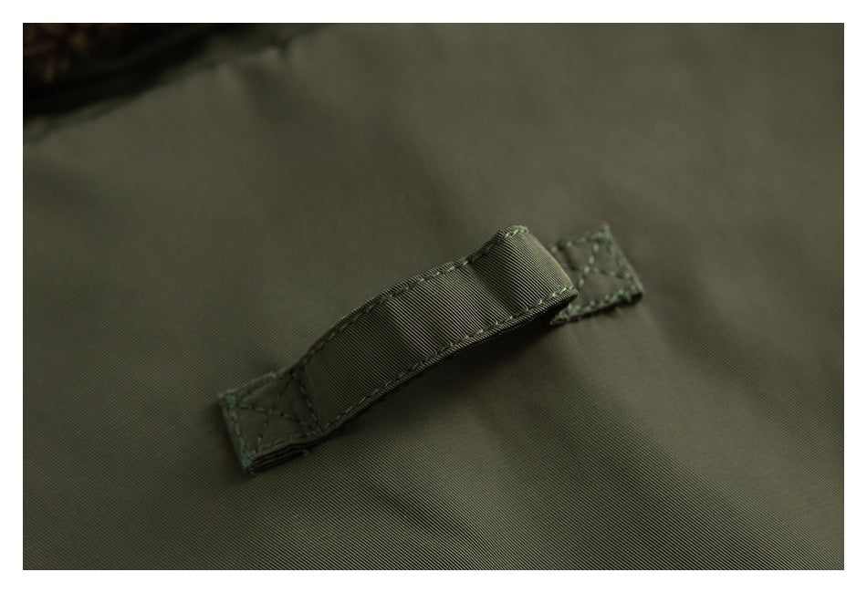 Close-up of an olive garment with a stitched fabric loop and reinforced ends.