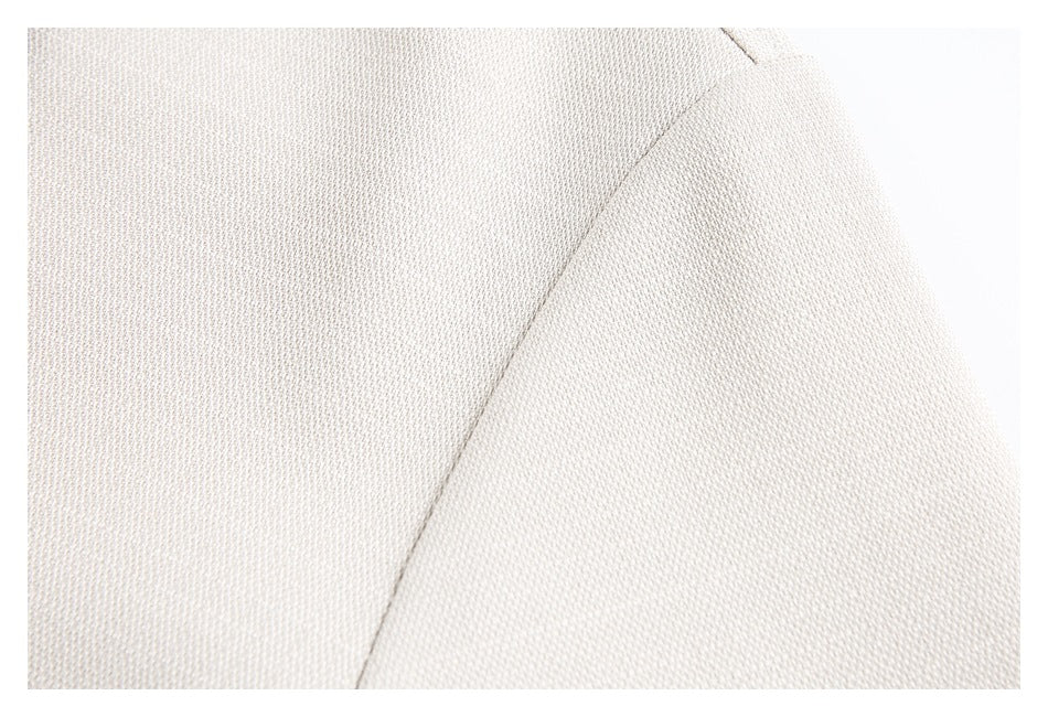 Close-up of ivory woven fabric with a curved stitched seam.