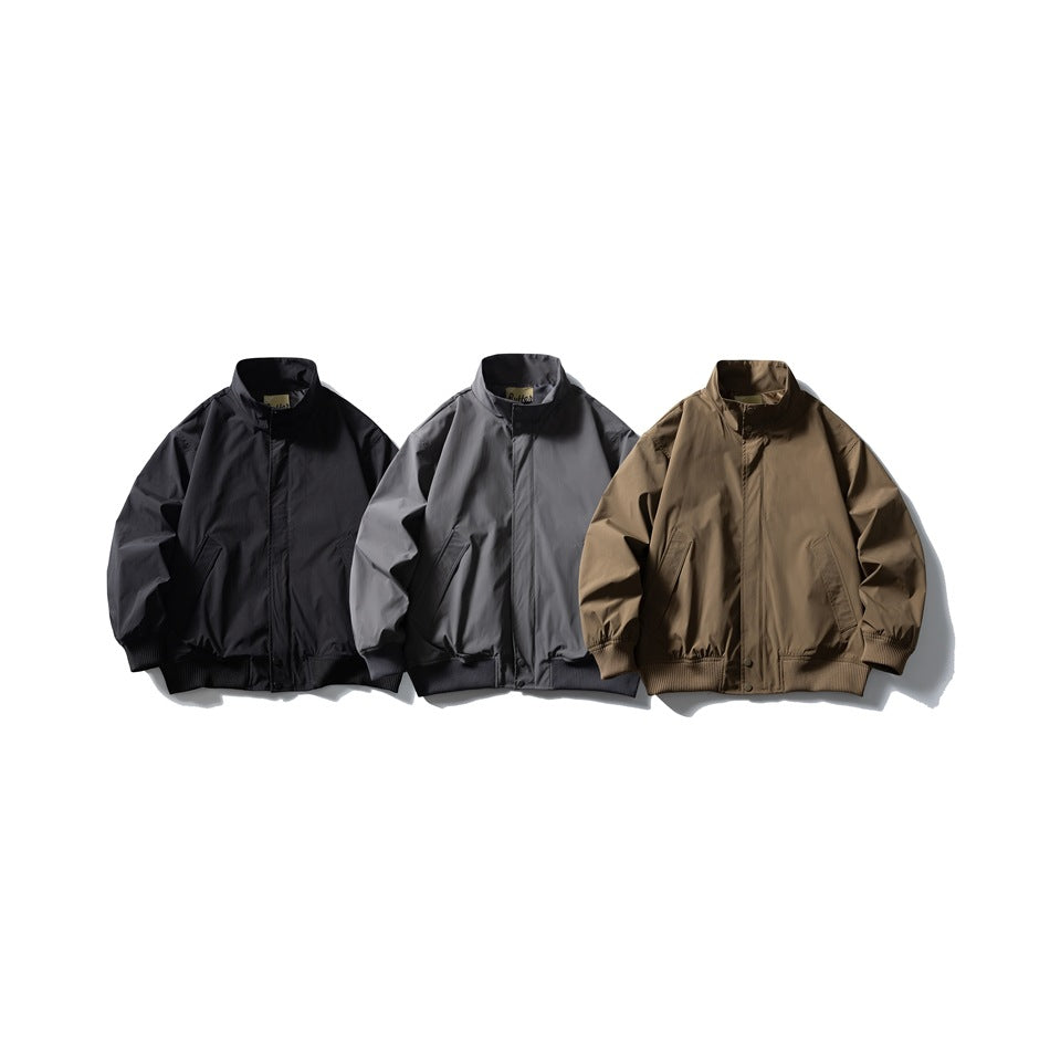 Three front-facing stand-collar jackets arranged together in black, gray, and brown, with ribbed cuffs and hems.