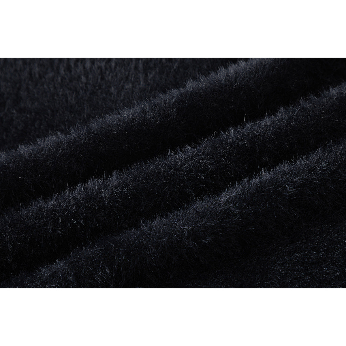 Extreme close-up showing the fuzzy black surface and folds of a sweater.