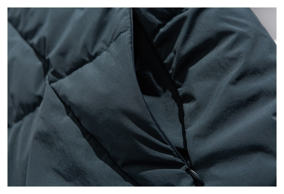 Close-up of a dark blue-gray jacket opening with a narrow black zipper and overlapping fabric.