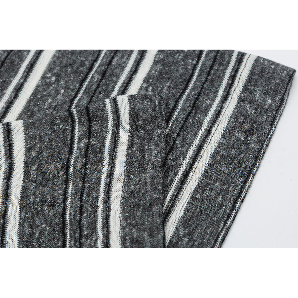 Close-up of charcoal gray fabric with white stripes and a finished stitched edge.