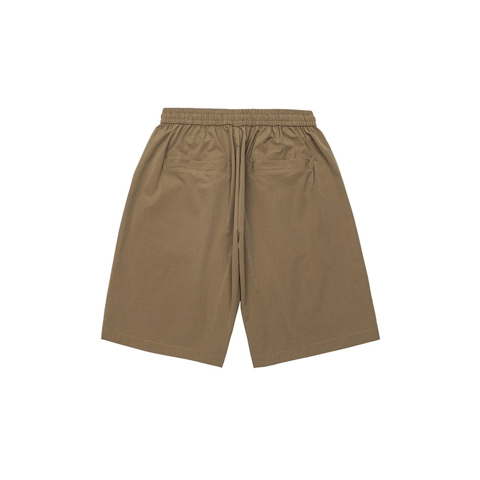 Back view of tan loose shorts with an elastic waistband, center drawstring, and two rear pockets.