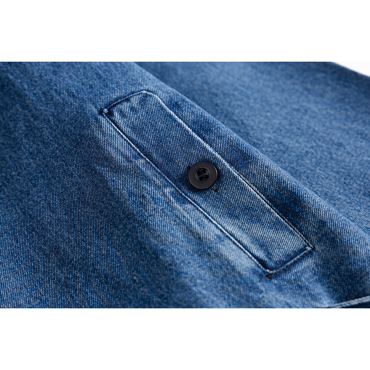 Close-up of a stitched button tab on blue denim fabric.
