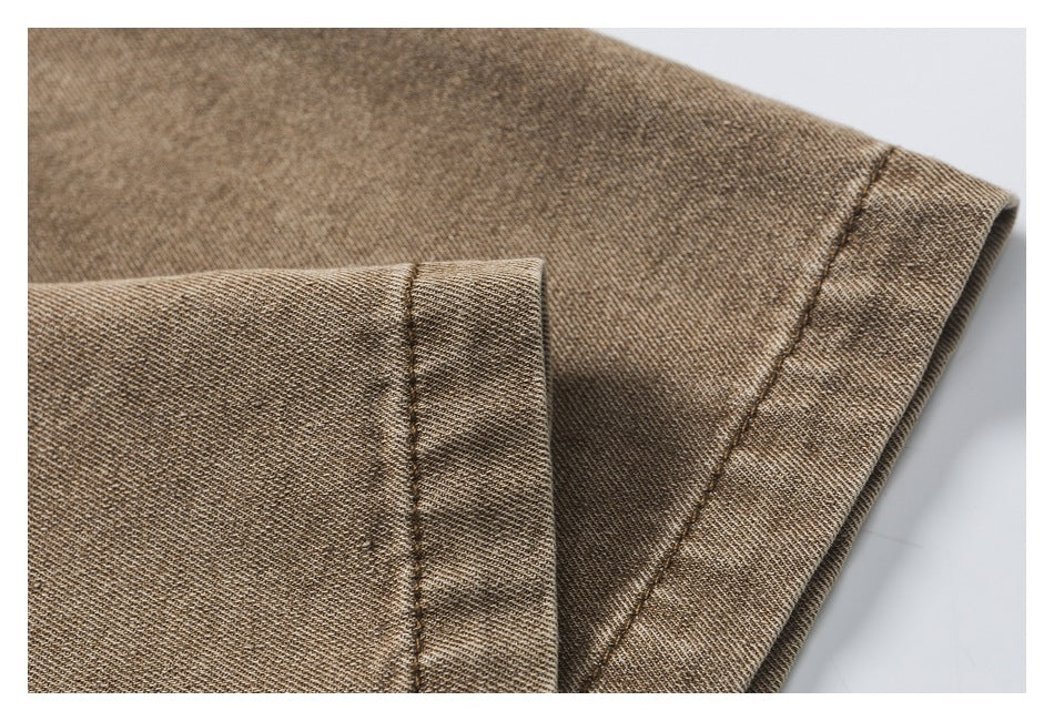 Close-up of a folded edge and stitched seam on brown twill fabric.