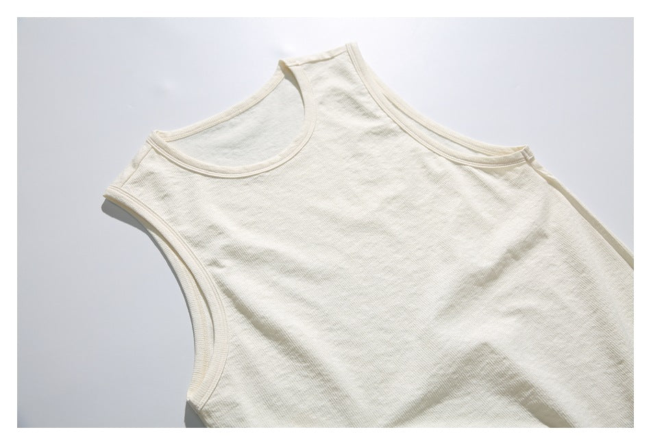 Close front view of a plain cream sleeveless tank top laid flat, cropped at the sides and bottom.