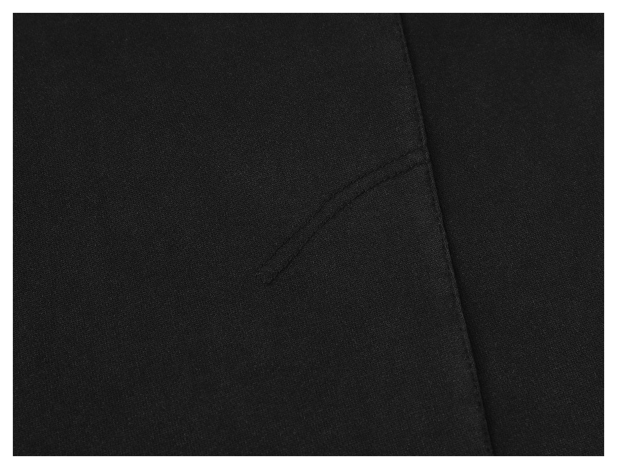 Close-up of black garment fabric with a diagonal stitched seam and a small reinforced opening.