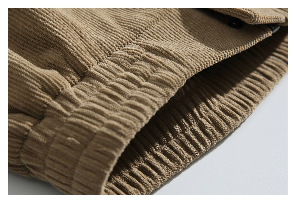 Close-up of gathered stitching and a ribbed edge on tan corduroy fabric.