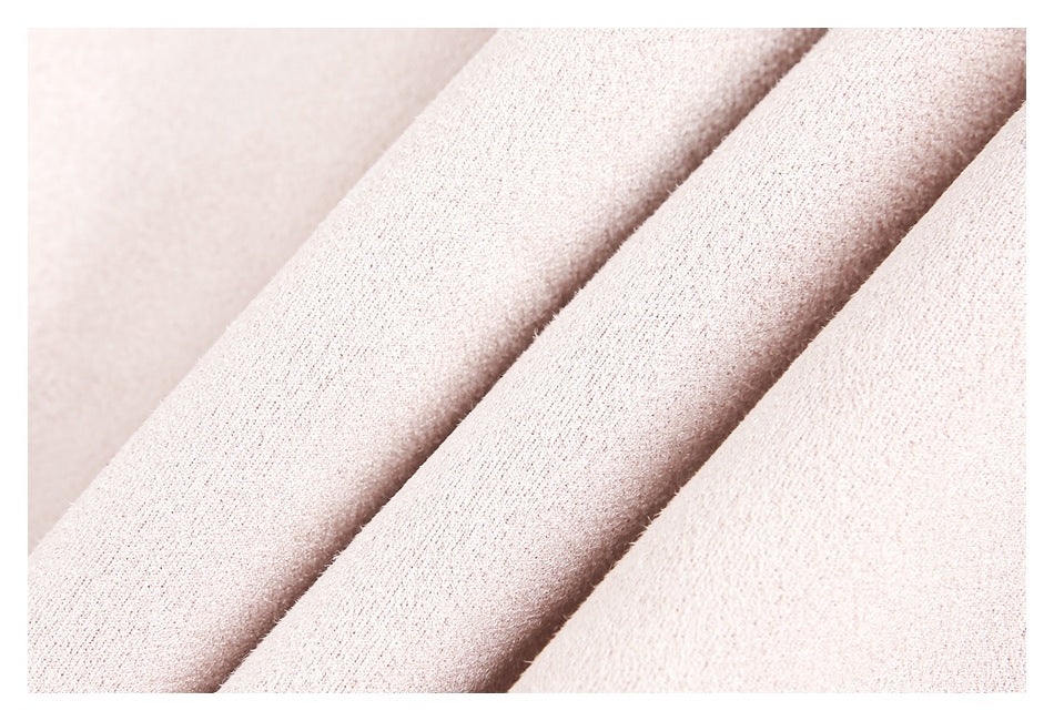 Macro view of the pale blush-pink garment fabric and its soft-looking surface texture.