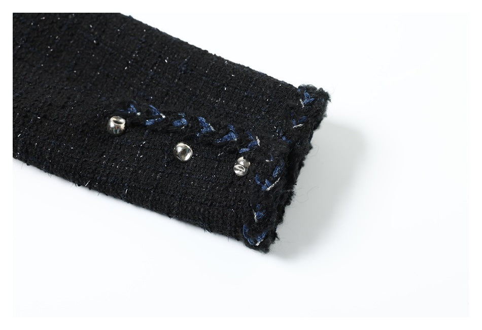 Black sleeve cuff with blue stitching and three small silver buttons.