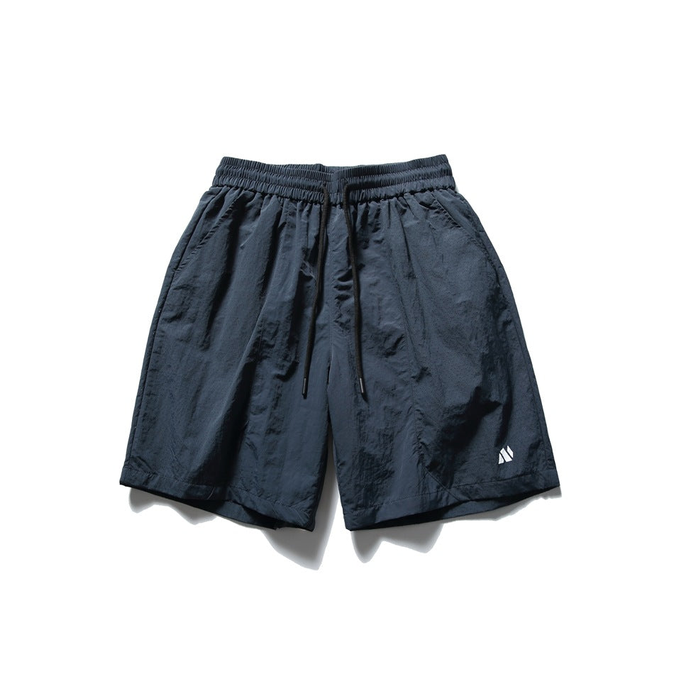 Navy blue knee-length drawstring shorts with elastic waist and small white logo, flat front view
