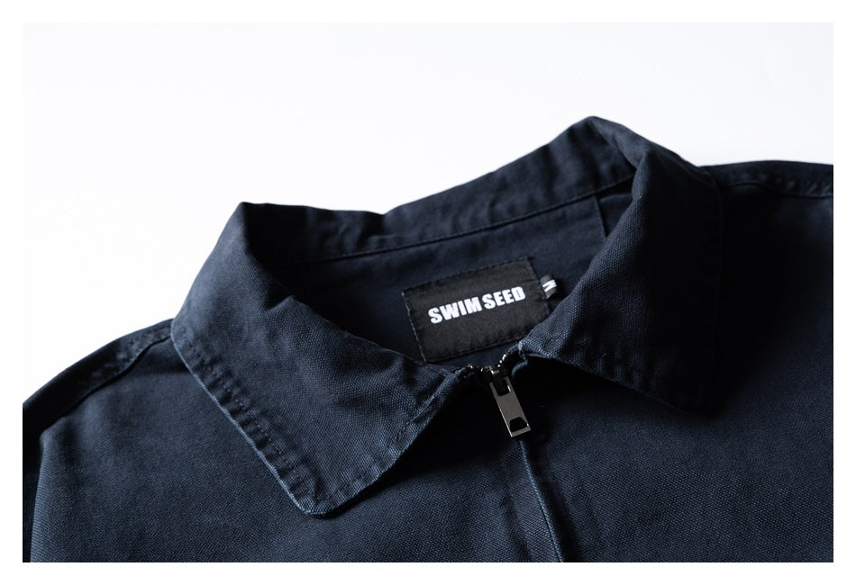Close-up of a dark navy jacket collar, front zipper and SWIM SEED neck label.