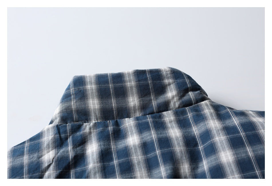 Close-up of a blue, gray, and white plaid shirt showing the collar and upper back.