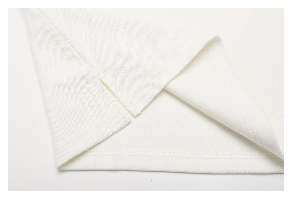 Close-up of an off-white polo shirt's folded hem and stitching.