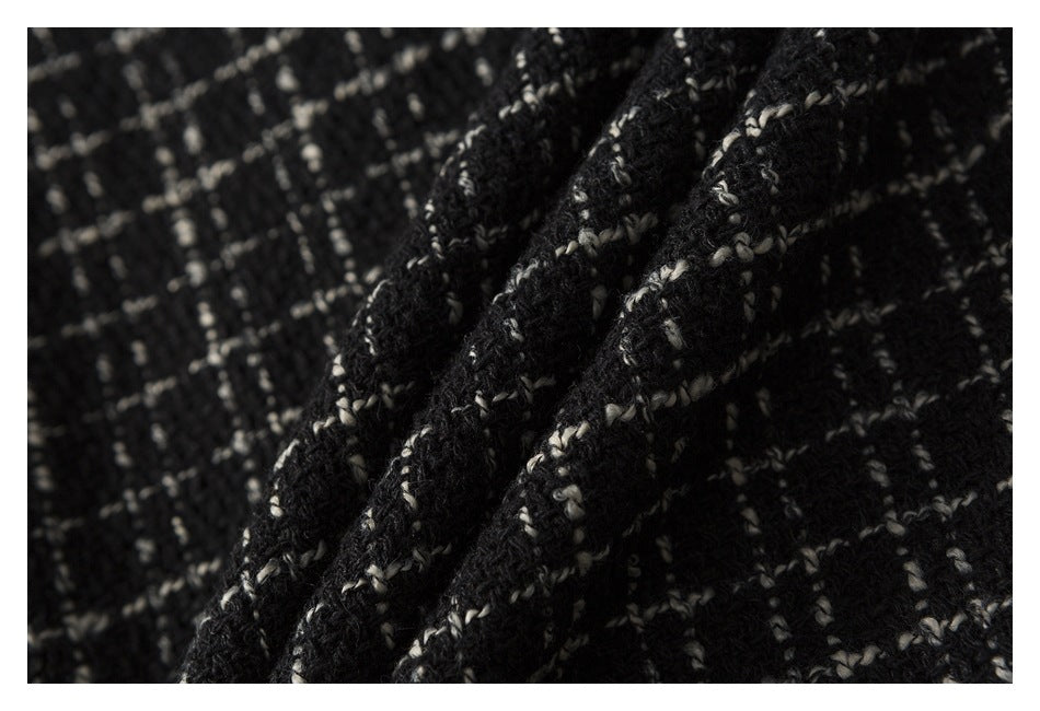 Close-up of black-and-cream textured fabric gathered into soft folds.