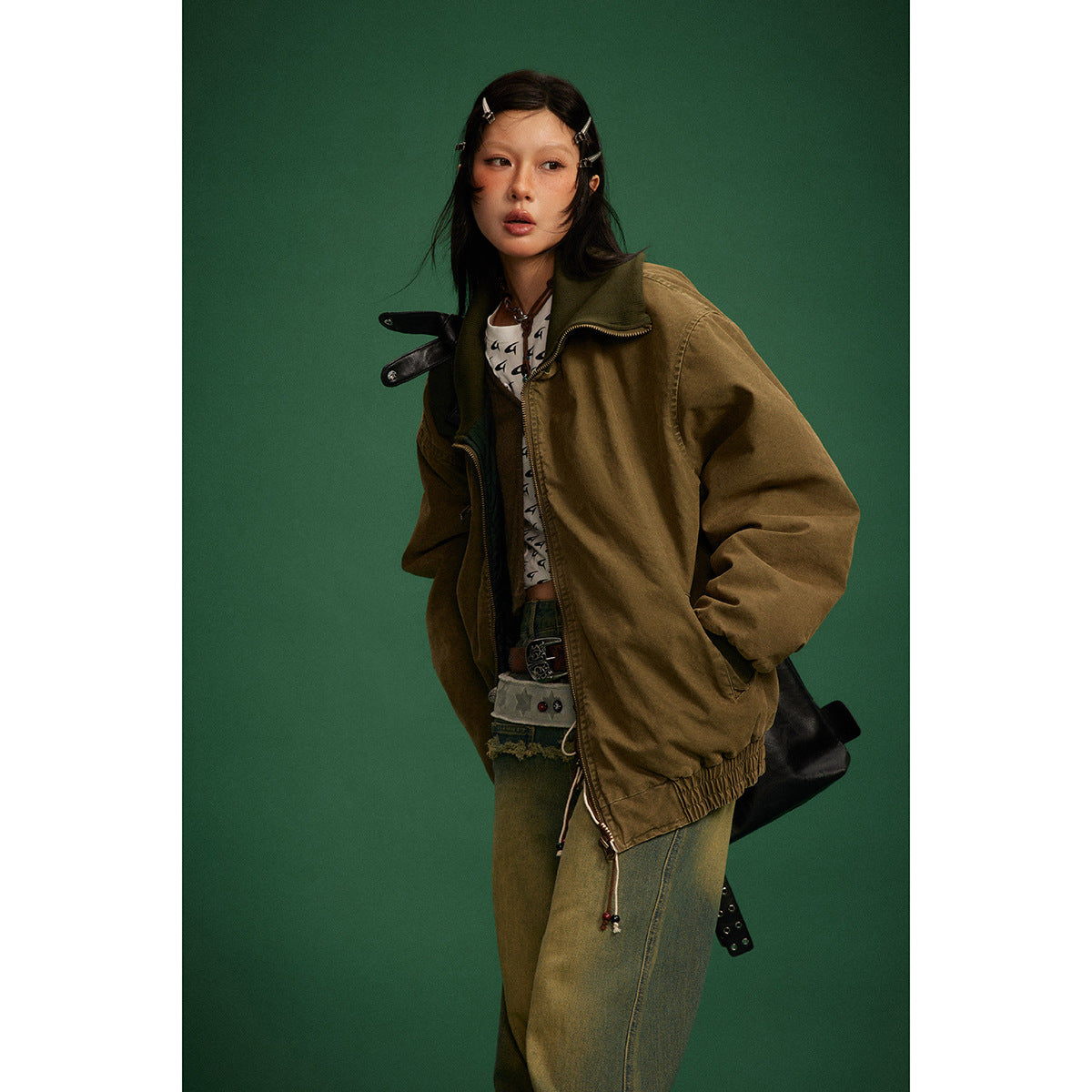 Model wearing an oversized brown jacket with a wide collar, zip closure, and front pockets.