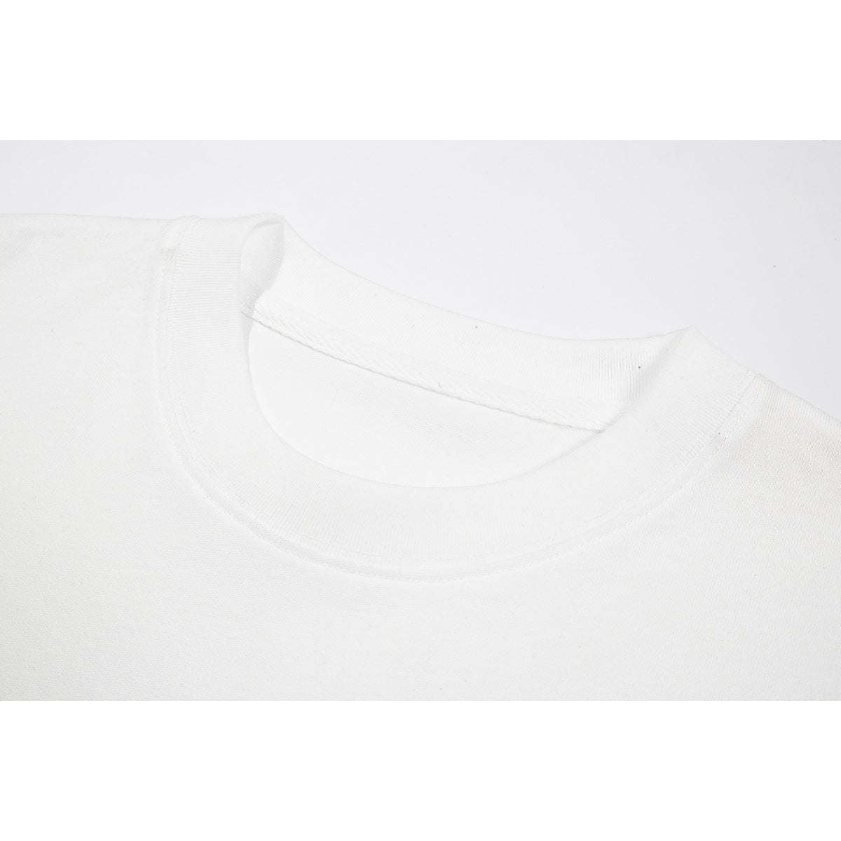 Close-up of a white T-shirt's ribbed crew neckline and shoulder seams.