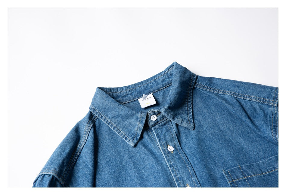 Flat-lay close-up of a blue denim shirt collar, button placket, and upper chest.