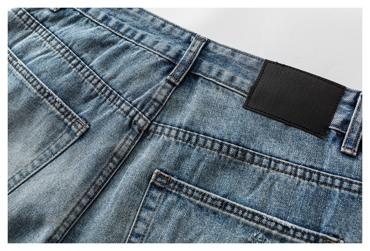 Close-up of the back waistband and pockets of faded blue jeans, including a plain black rectangular patch.