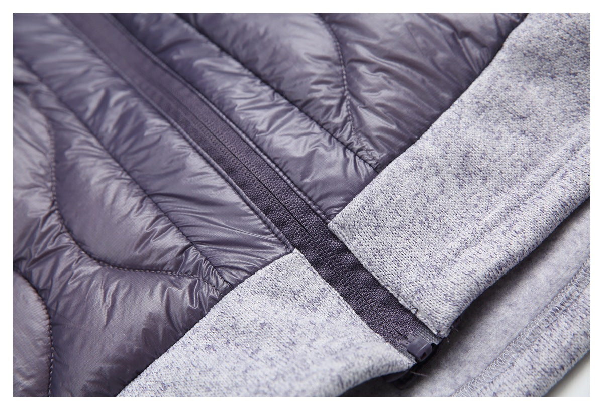 Close-up of the jacket’s center zipper, plum quilted panels, and gray marled knit hem.