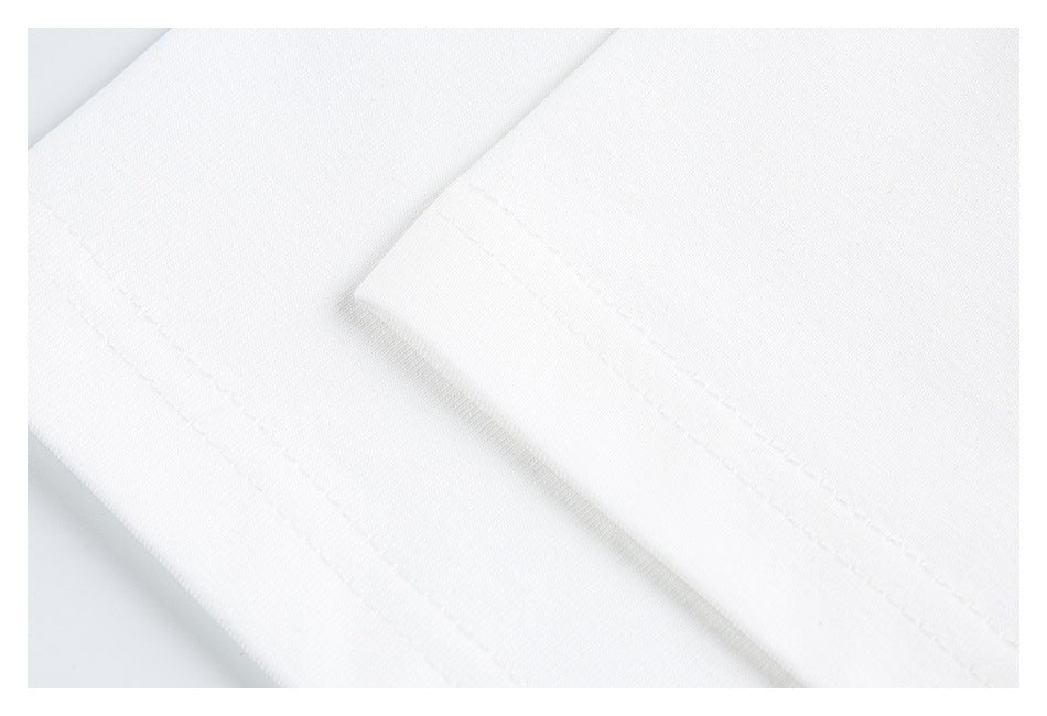 Close-up of white garment fabric with a stitched folded edge.
