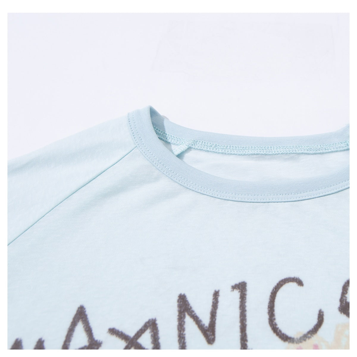 Close-up of a pale blue T-shirt's ribbed crew neckline and partial printed lettering.