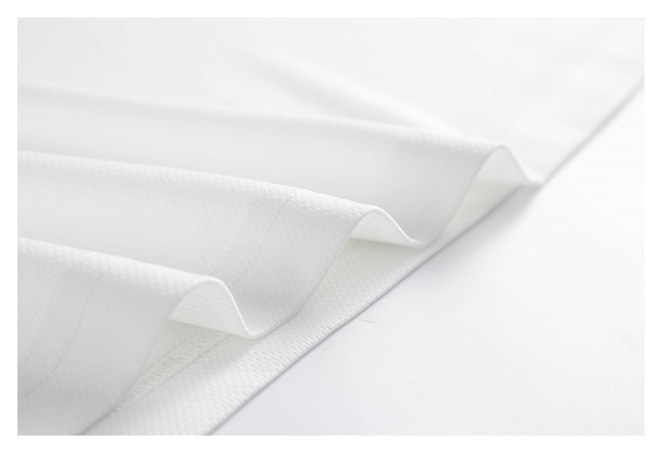 Close-up of white fabric folded in soft waves, showing its fine textured surface and finished edge.
