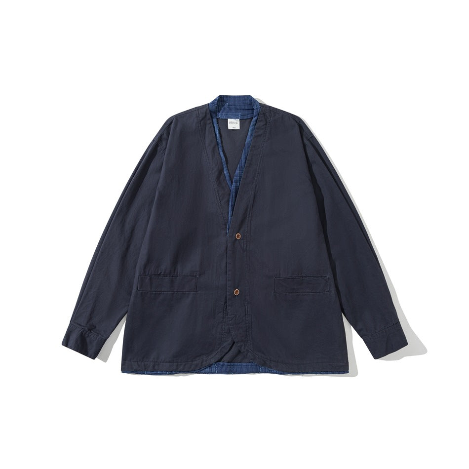 Navy collarless V-neck jacket, flat lay front view, with two buttons, flap pockets and blue plaid trim