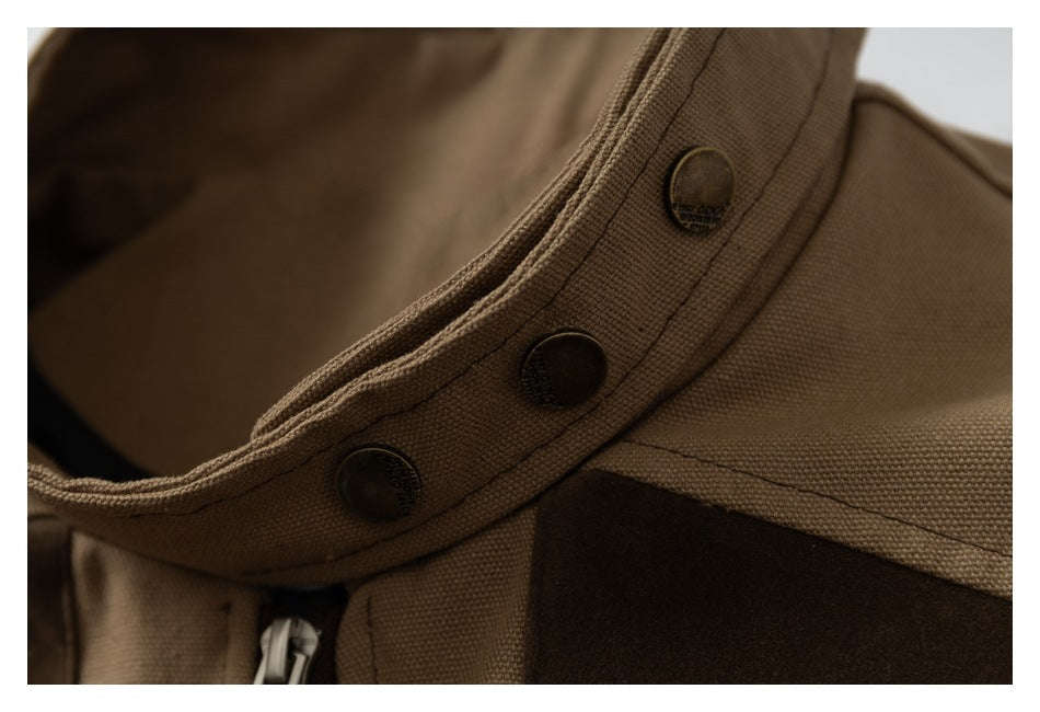 Close-up of three dark snap buttons on the tan collar trim of the jacket.