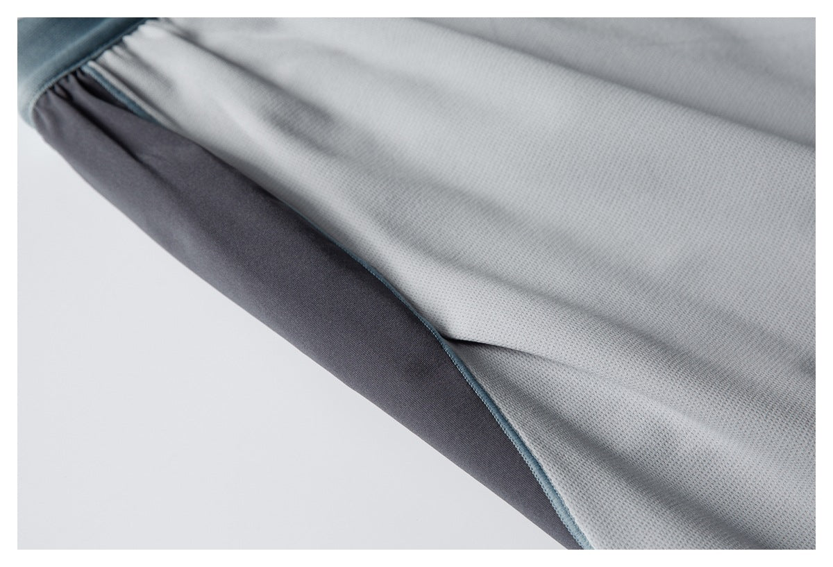 Close-up of a light gray garment edge with dark gray lining and blue-gray piping.