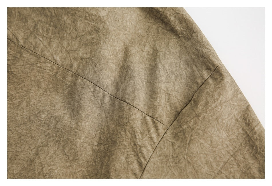 Close-up of taupe-brown mottled fabric showing intersecting stitched seams.