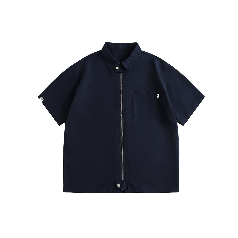Navy short-sleeve zip-front shirt with collar, chest pocket and hem snap tab, flat lay on white