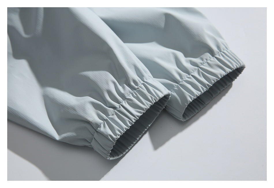 Close-up of gathered elastic openings on pale blue-gray garment fabric.