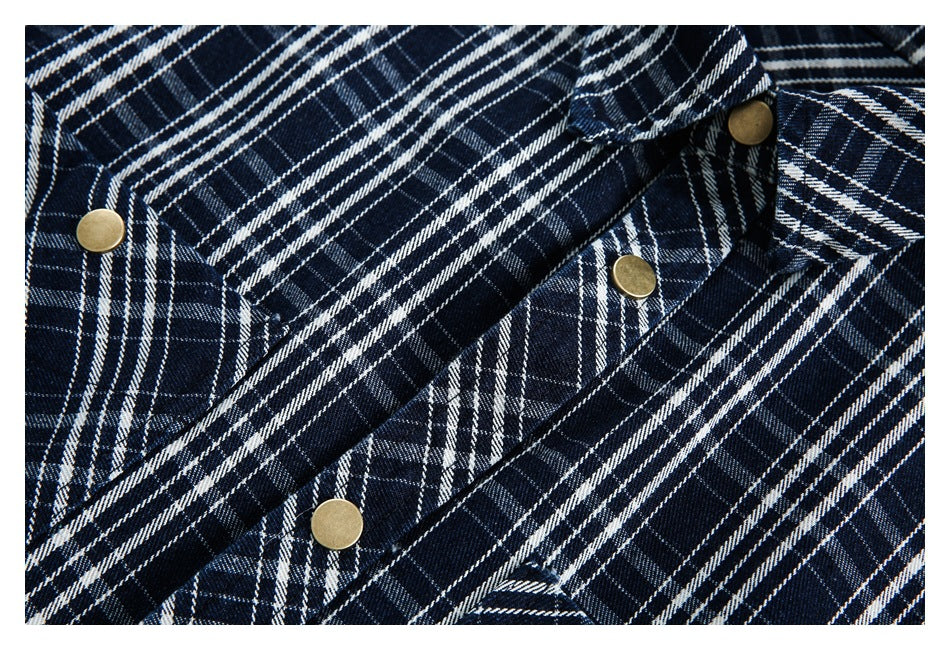 Close-up of the navy-and-white plaid pattern, angled pocket seams, and brass-tone snap fasteners.